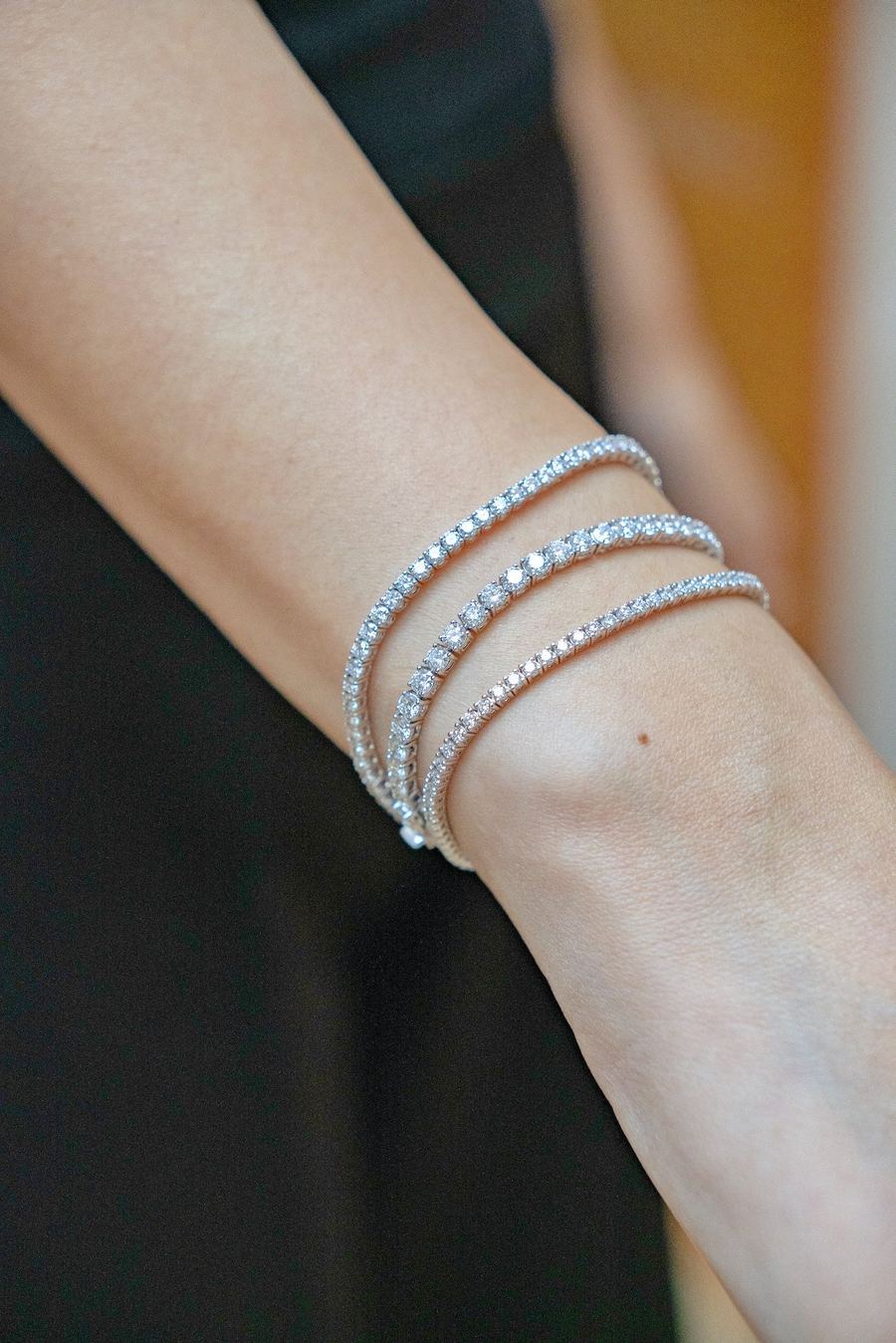 Close-up of diamond tennis bracelets stacked on a wrist